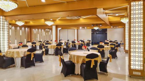 a banquet hall with tables and chairs in a room at Hotel Golf View Sakura & Suites in Gurgaon