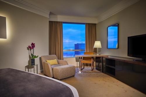 a hotel room with a bedroom with a large window at Hyatt Regency Belgrade in Belgrade