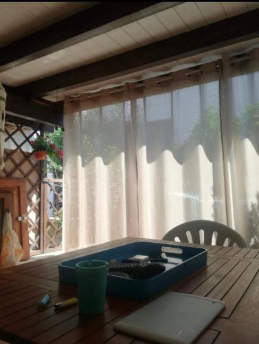 a blue lunch box sitting on a wooden table at Casa Aaron - Monolocale con veranda sul mare in Stintino