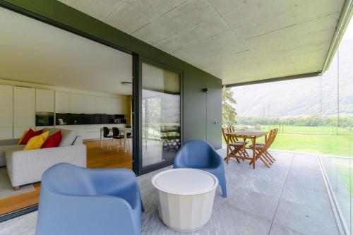 a living room with blue chairs and a table at Residenza Ticino by Quokka 360 - Modern Oasis near Bellinzona in Bellinzona