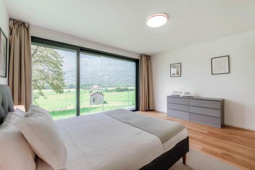 a bedroom with a large window and a large bed at Residenza Ticino by Quokka 360 - Modern Oasis near Bellinzona in Bellinzona