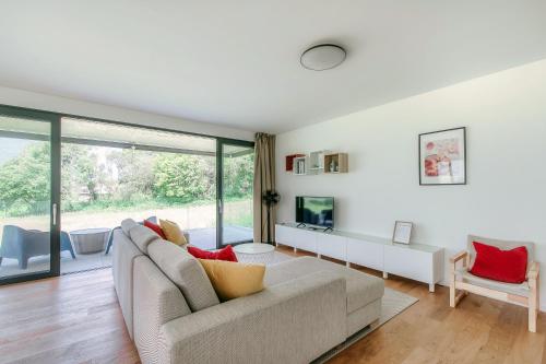 a living room with a couch and a large window at Residenza Ticino by Quokka 360 - Modern Oasis near Bellinzona in Bellinzona