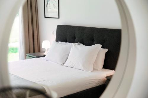 a bedroom with a bed with a black headboard and white pillows at Residenza Ticino by Quokka 360 - Modern Oasis near Bellinzona in Bellinzona