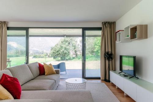 a living room with a couch and a television at Residenza Ticino by Quokka 360 - Modern Oasis near Bellinzona in Bellinzona