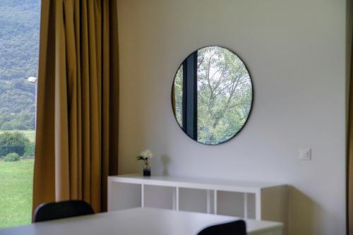 a room with a round mirror on the wall at Residenza Ticino by Quokka 360 - Modern Oasis near Bellinzona in Bellinzona