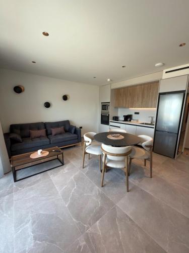 a living room with a couch and a table and chairs at Costa Blu mare in Haraki