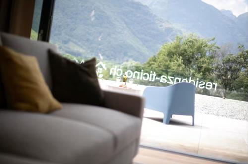 a cat sitting on a couch in front of a window at Residenza Ticino by Quokka 360 - Modern Oasis near Bellinzona in Bellinzona