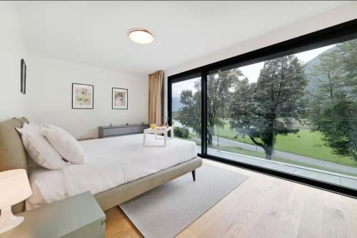 a bedroom with a bed and a large window at Residenza Ticino by Quokka 360 - Modern Oasis near Bellinzona in Bellinzona