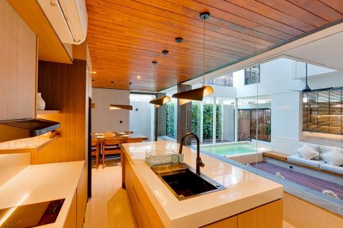 a kitchen with a sink and a living room at NEW! Luxury Modern 3BR Villa Kesatu in Canggu in Canggu