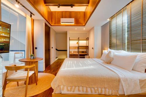 a bedroom with a large white bed and a chair at NEW! Luxury Modern 3BR Villa Kesatu in Canggu in Canggu
