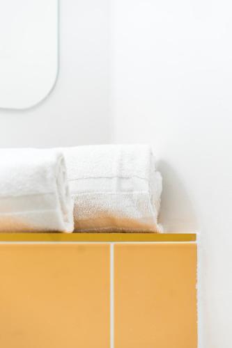 two towels sitting on top of a yellow shelf at Grand Juste in Marseille
