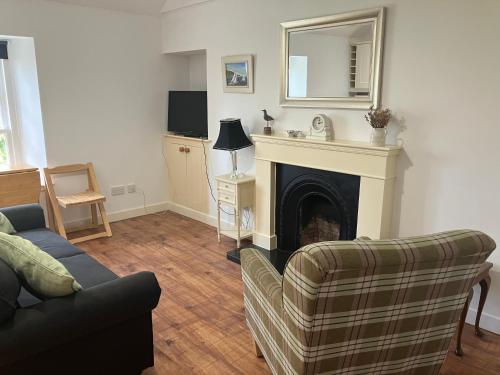 ein Wohnzimmer mit Couch und Kamin in der Unterkunft Berryhill Maids Quarters - 3 bedroom - Self Catering - Sleeps 3 - Dogs Welcome - Off-road Parking - Suit Contractors - Peterhead 1 mile - Newly Refurbished - Open plan kitchen -living - dining - 2 bathroom - Shed - Yard -Drying Room available in Peterhead