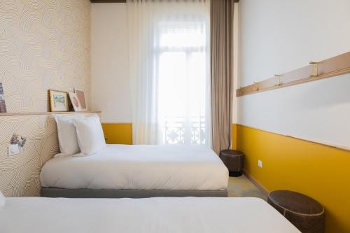 a hotel room with two beds and a window at Grand Juste in Marseille