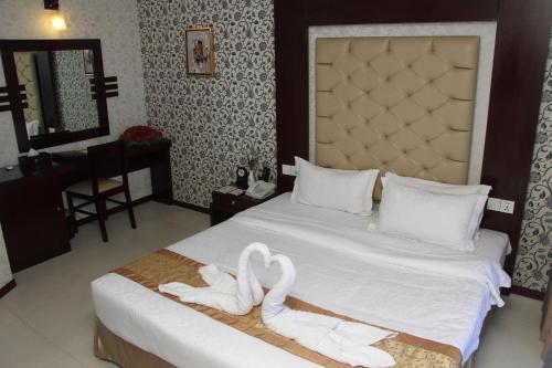 a bedroom with a bed with two white towels on it at The Cox Today Limited in Cox's Bazar
