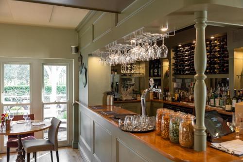 Un bar en un restaurante con una mesa y sillas. en Wingrove House, en Alfriston