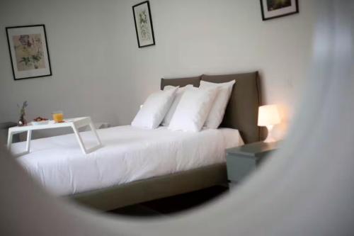 a bedroom with a white bed and a table at Residenza Ticino by Quokka 360 - Modern Oasis near Bellinzona in Bellinzona