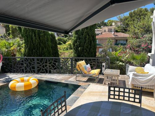uma piscina com um guarda-sol, uma mesa e cadeiras em T3 luxe vue mer em Cassis
