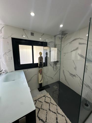 La salle de bains est pourvue d'une douche avec une statue d'homme. dans l'établissement T3 luxe vue mer, à Cassis