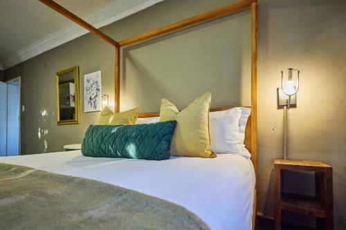 a bed with a green pillow on it in a room at Boord Guest House in Stellenbosch