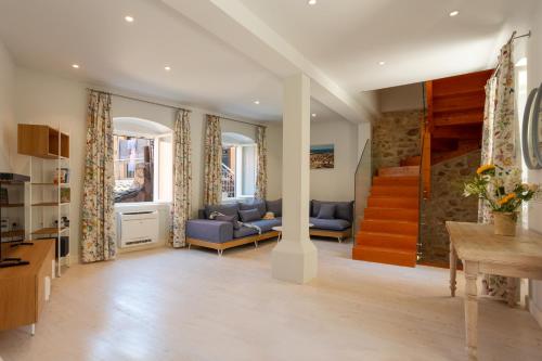 CorfuIonea House的客厅里有一张蓝色的沙发和一座楼梯