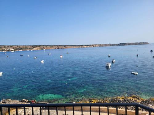 a large body of water with boats in it at Seafront Penthouse with Large Terrace and Panoramic Views-Mellieha Bay Ghadira in Mellieħa