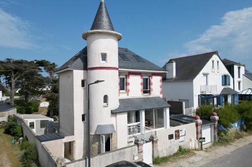 une maison avec une tourelle au bord d'une rue dans l'établissement T2 rénové Terrasse & Vue mer 180 et charme, à Saint-Pierre-Quiberon