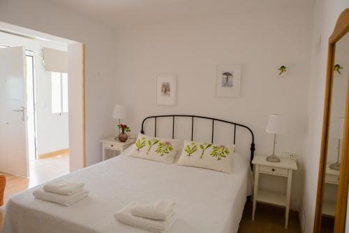 a bedroom with a white bed with two towels on it at Apartamentos Casa Torres - Adults Only in Albir