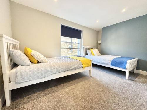 een slaapkamer met twee bedden en een raam bij Castle Cottage - Central seaside town in Ryde