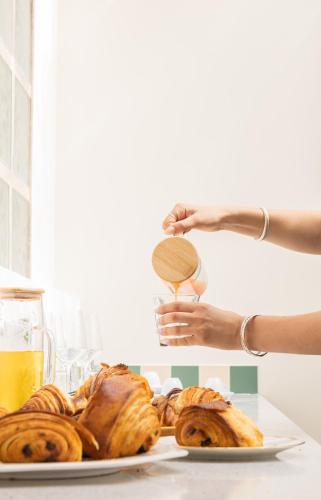 a person holding a wooden spoon over a plate of pastries at Grand Juste in Marseille