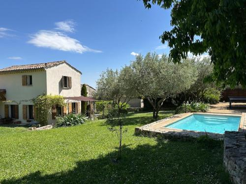 a house and a swimming pool in a yard at Le Mas des Remparts in Vézénobres