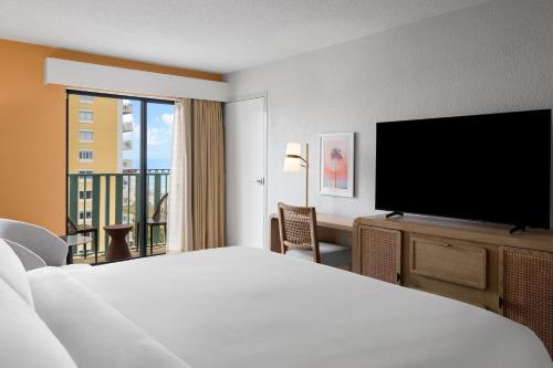 a hotel room with a bed and a flat screen tv at voco The Shelby - Myrtle Beach by IHG in Myrtle Beach