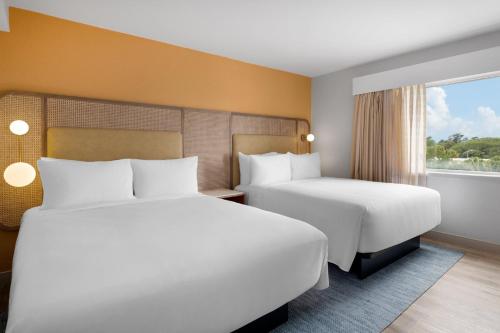 a hotel room with two beds and a window at voco The Shelby - Myrtle Beach by IHG in Myrtle Beach