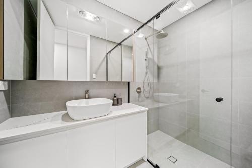 a white bathroom with a sink and a shower at Scarborough Escape, New 2Br Suite, 14G in Perth