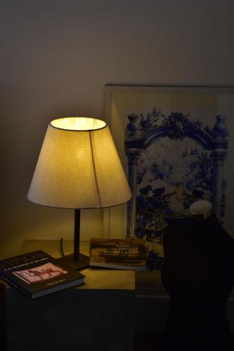 a lamp sitting on top of a table with a book at ArtNEST Gallery Stay , Pedlars St , Galle Fort in Galle