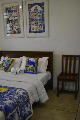 a bedroom with two beds and a chair and pictures on the wall at ArtNEST Gallery Stay , Pedlars St , Galle Fort in Galle