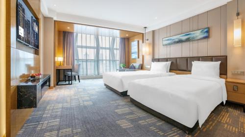 a hotel room with two beds and a television at Lyhn International Hotel Chengdu Taikoo Li in Chengdu