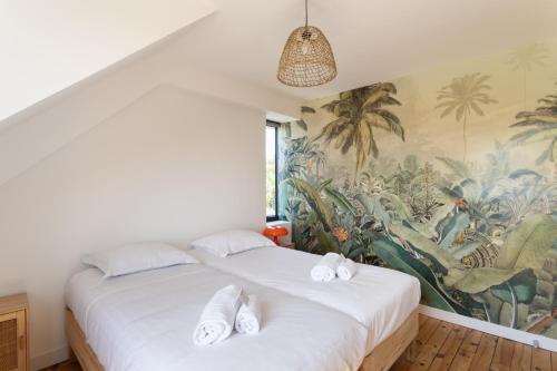 two beds in a room with a mural at La Si Lancieuse - Maison spacieuse in Lancieux