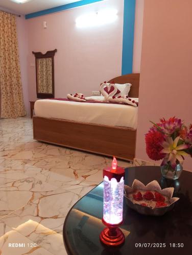a bedroom with a bed and a table with a candle at Sharma Jee Farm House Yercaud in Yercaud