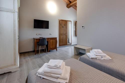 a room with two beds and a desk and a television at Il Borghetto Bed and Breakfast in Borgo San Lorenzo