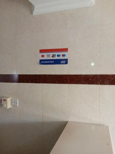 a sign on a wall next to a toilet at Rising Sun Hotel in Mwanza