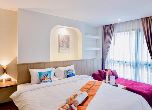 a hotel room with two beds and a window at Metro Hotel Phahonyothin 35 in Bangkok