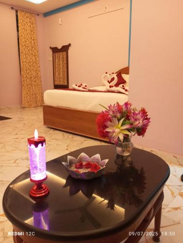 a room with a table with a candle and a bed at Sharma Jee Farm House Yercaud in Yercaud