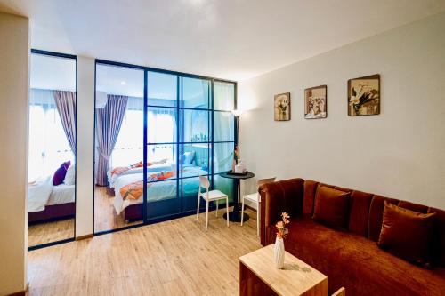 a living room with a couch and a bedroom at Metro Hotel Phahonyothin 35 in Bangkok