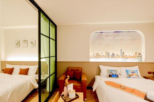 a hotel room with two beds and a window at Metro Hotel Phahonyothin 35 in Bangkok