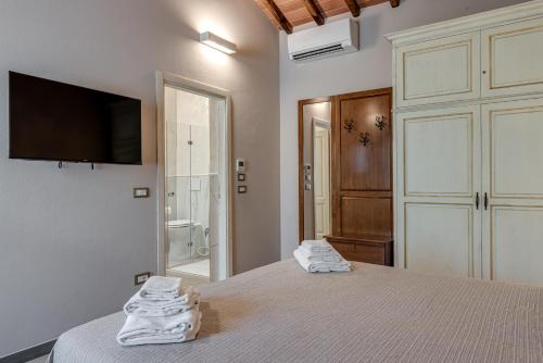 a bedroom with a bed and a tv on the wall at Il Borghetto Bed and Breakfast in Borgo San Lorenzo