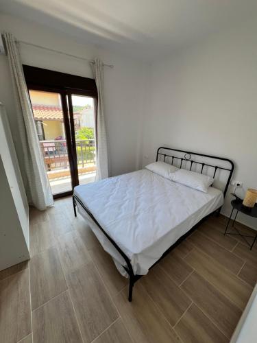 a bedroom with a large bed with white sheets at Nicks apartments in Ierissos
