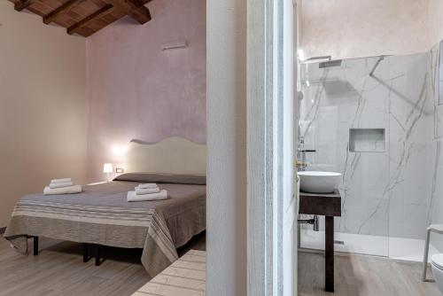 a bedroom with a bed and a shower and a sink at Il Borghetto Bed and Breakfast in Borgo San Lorenzo