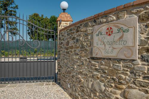 a sign on a stone wall next to a gate at Il Borghetto Bed and Breakfast in Borgo San Lorenzo