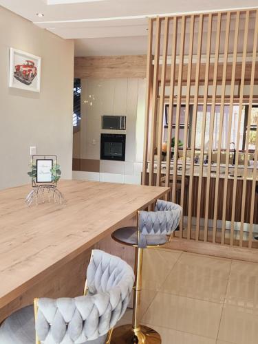 a kitchen with a large wooden counter and chairs at Eastern Road Executive Suites in Harare