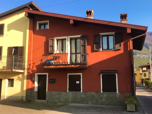 a red and white house with a balcony at La casa rossa in Costa Volpino